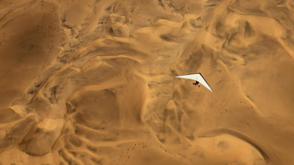 An ultralight aircraft flying over the sands of Namibia