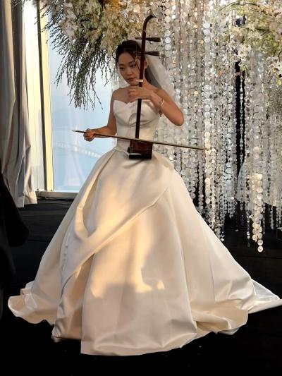 Wearing a Western wedding dress and playing the Chinese Erhu