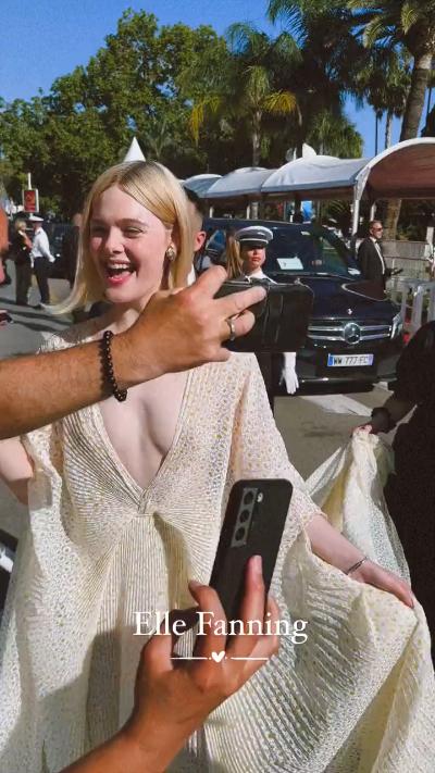 Elle Fanning poses with fans in low-cut dress