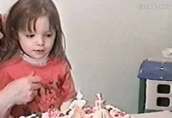 kid blows out candles GIF