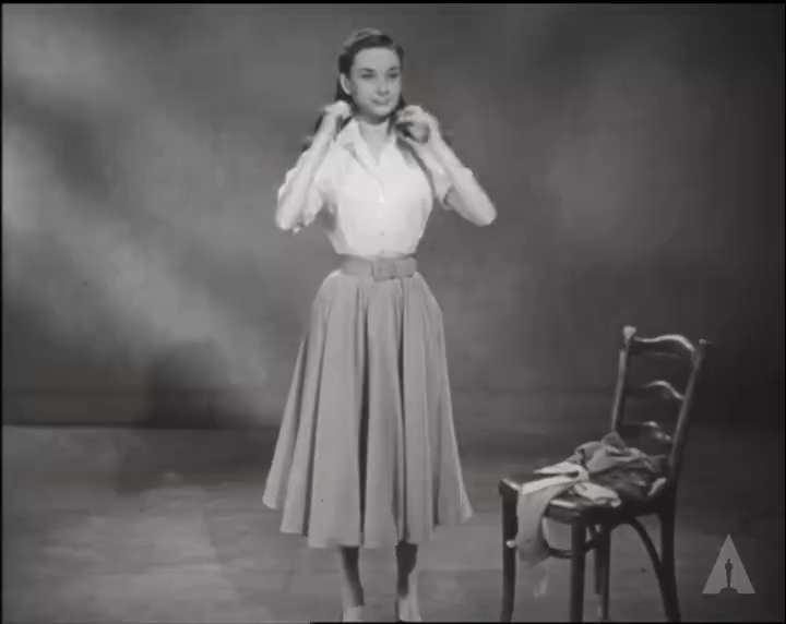 Audrey Hepburn adjusts her scarf and spins in circles