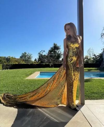 Nicole Kidman drags the hem of her golden gown