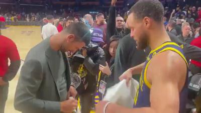 Curry and Djokovic exchange autographs after the game