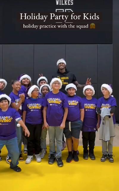 Lakers player Vanderbilt poses with children wearing Santa hats