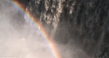 A rainbow created by a waterfall in Iceland GIF
