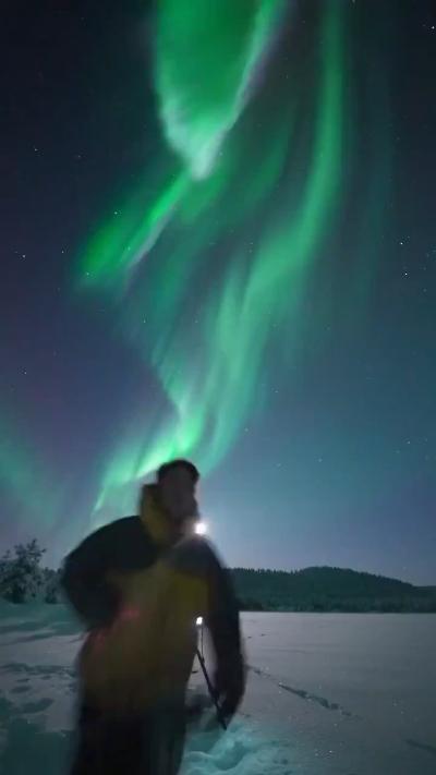Green aurora and cheering people